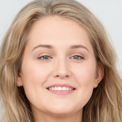 Joyful white young-adult female with long  brown hair and blue eyes