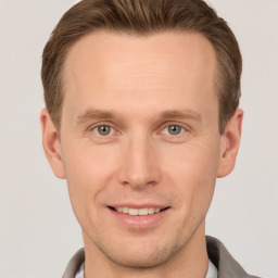 Joyful white young-adult male with short  brown hair and grey eyes