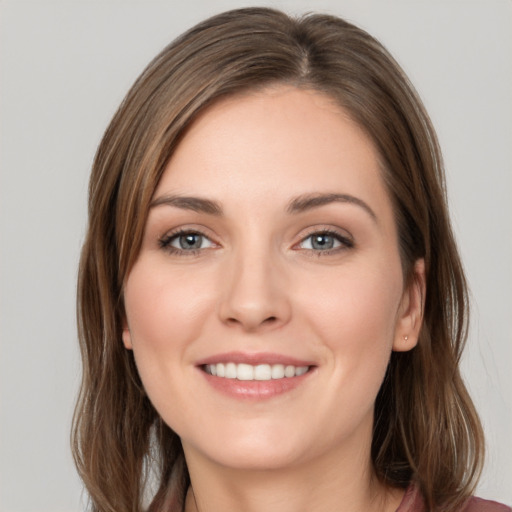 Joyful white young-adult female with long  brown hair and grey eyes