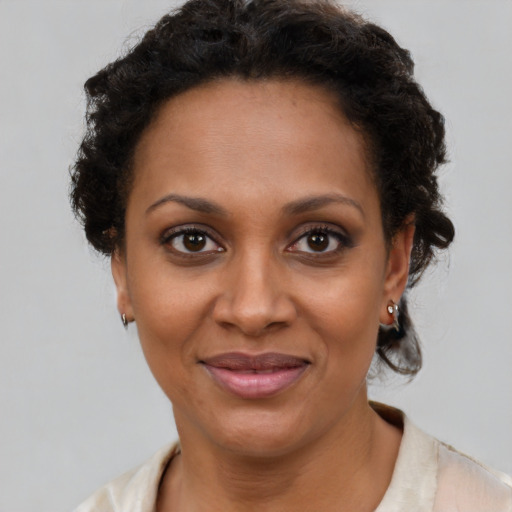 Joyful black young-adult female with short  brown hair and brown eyes