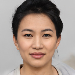 Joyful asian young-adult female with medium  black hair and brown eyes