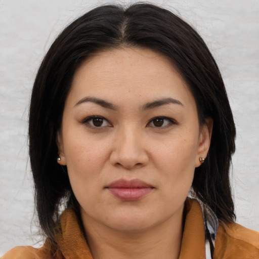 Joyful asian adult female with medium  brown hair and brown eyes