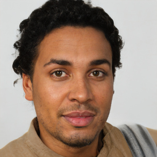 Joyful latino young-adult male with short  brown hair and brown eyes