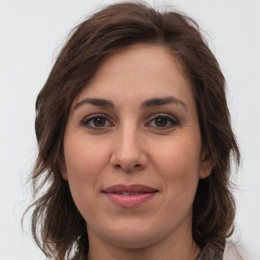 Joyful white adult female with medium  brown hair and grey eyes