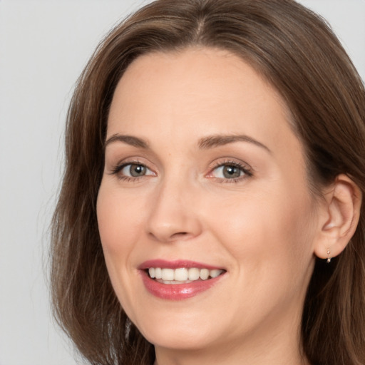 Joyful white adult female with long  brown hair and brown eyes