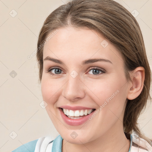 Joyful white young-adult female with medium  brown hair and grey eyes