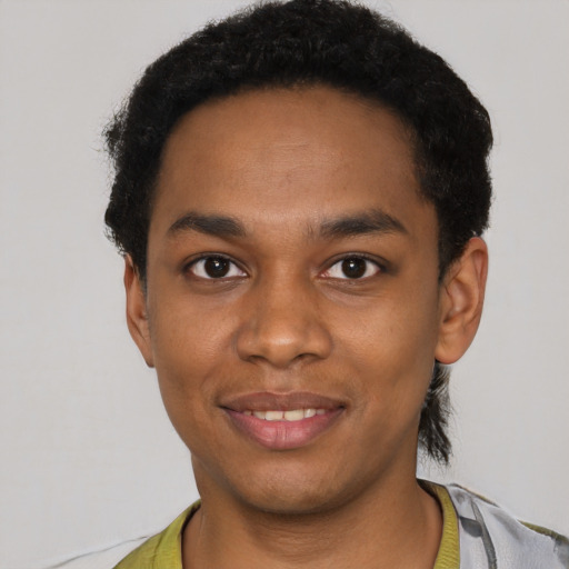 Joyful black young-adult male with short  black hair and brown eyes