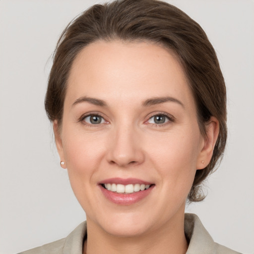 Joyful white young-adult female with medium  brown hair and grey eyes