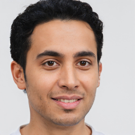 Joyful latino young-adult male with short  brown hair and brown eyes