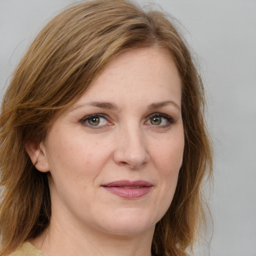 Joyful white adult female with medium  brown hair and green eyes