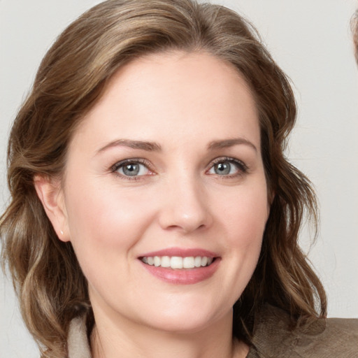 Joyful white young-adult female with medium  brown hair and blue eyes