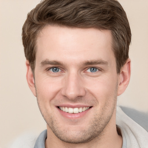 Joyful white young-adult male with short  brown hair and grey eyes