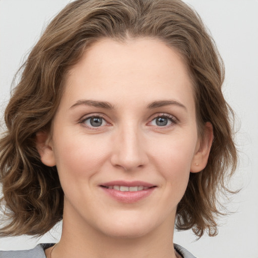 Joyful white young-adult female with medium  brown hair and blue eyes