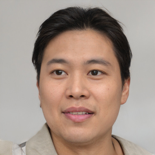 Joyful asian adult male with short  brown hair and brown eyes