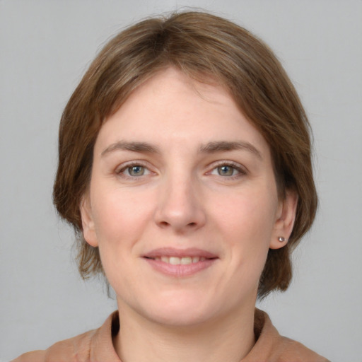 Joyful white young-adult female with medium  brown hair and grey eyes