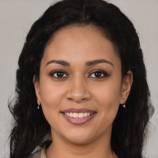 Joyful latino young-adult female with long  brown hair and brown eyes