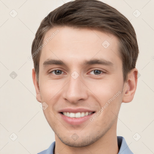 Joyful white young-adult male with short  brown hair and grey eyes