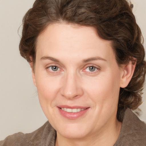 Joyful white adult female with medium  brown hair and grey eyes