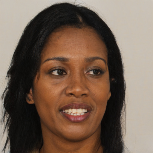 Joyful black adult female with long  brown hair and brown eyes