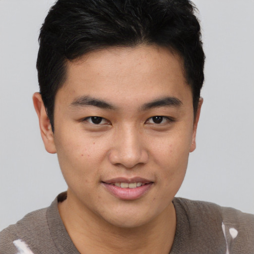 Joyful asian young-adult male with short  brown hair and brown eyes