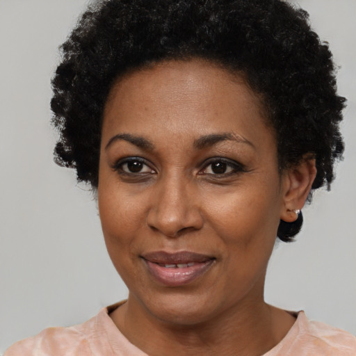 Joyful black adult female with short  black hair and brown eyes