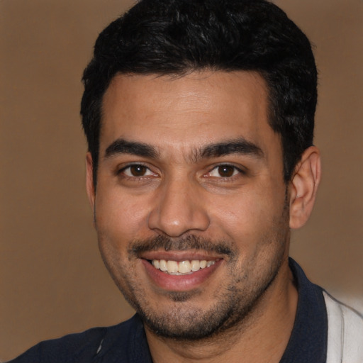 Joyful latino young-adult male with short  black hair and brown eyes