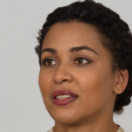 Joyful black young-adult female with short  black hair and brown eyes