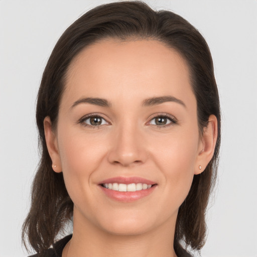 Joyful white young-adult female with long  brown hair and brown eyes