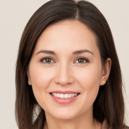 Joyful white young-adult female with long  brown hair and brown eyes