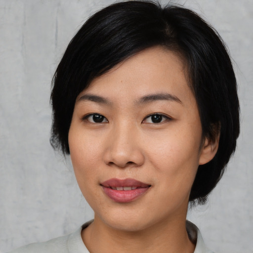 Joyful asian young-adult female with medium  black hair and brown eyes