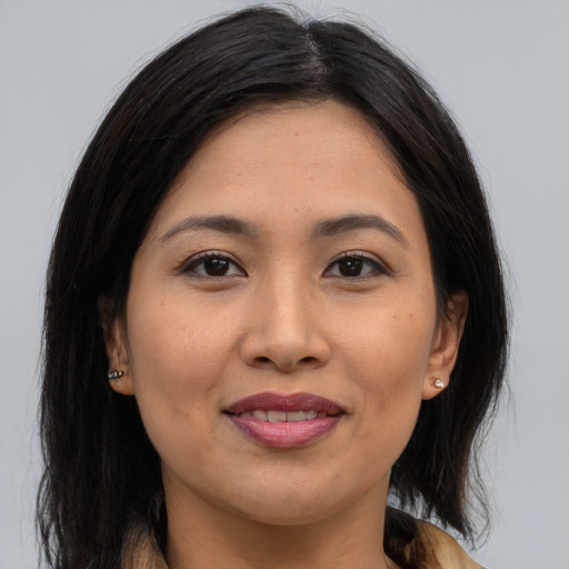 Joyful asian adult female with long  brown hair and brown eyes