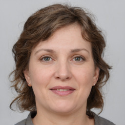 Joyful white adult female with medium  brown hair and grey eyes