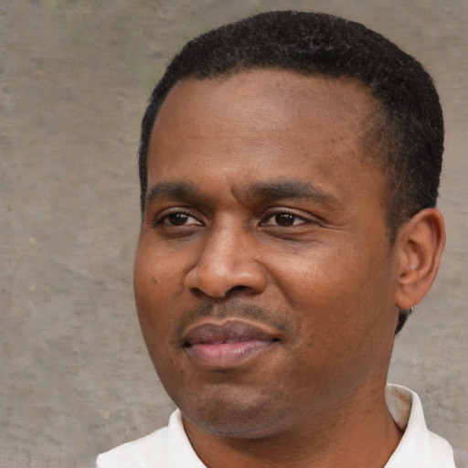 Joyful black young-adult male with short  black hair and brown eyes
