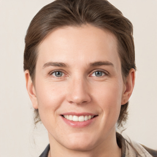 Joyful white young-adult female with medium  brown hair and grey eyes