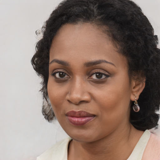Joyful black young-adult female with medium  brown hair and brown eyes