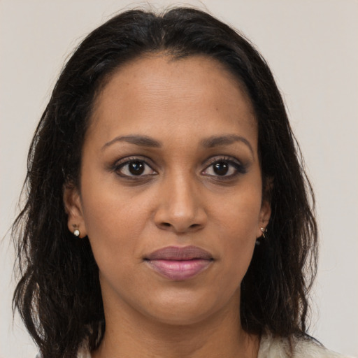 Joyful black young-adult female with long  brown hair and brown eyes