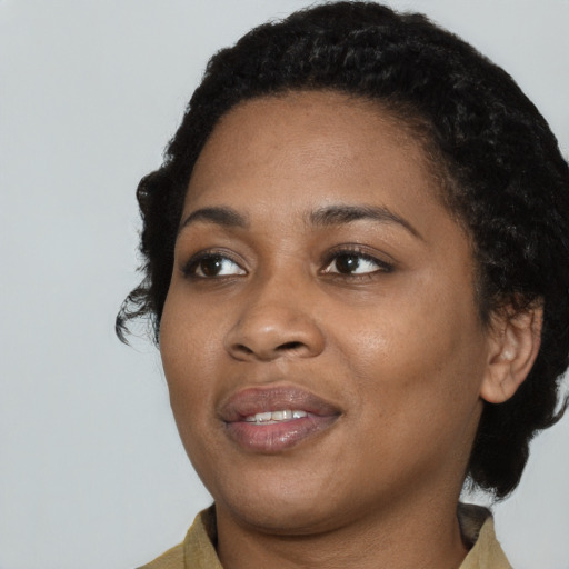Joyful black young-adult female with medium  black hair and brown eyes