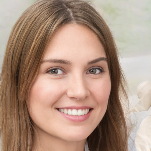 Joyful white young-adult female with long  brown hair and green eyes