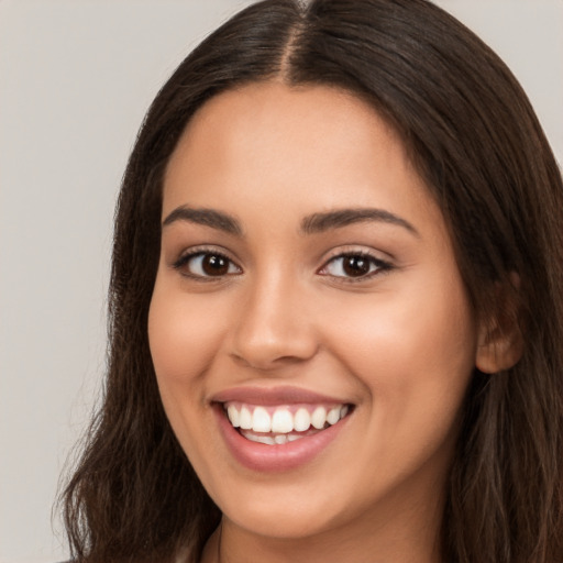 Joyful white young-adult female with long  brown hair and brown eyes