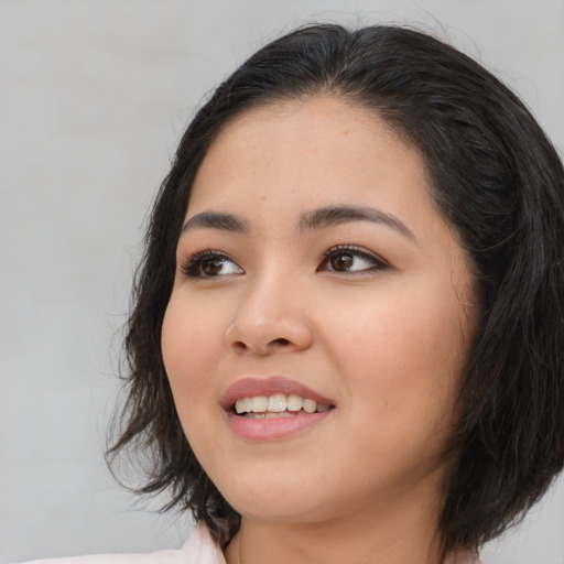 Joyful asian young-adult female with long  black hair and brown eyes