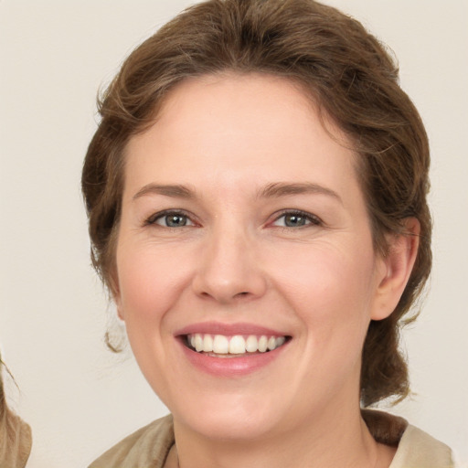 Joyful white young-adult female with medium  brown hair and grey eyes