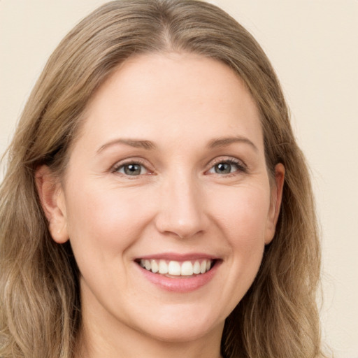 Joyful white young-adult female with long  brown hair and green eyes