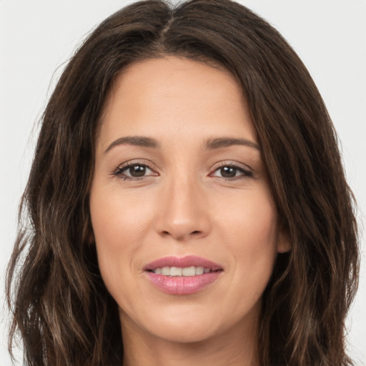 Joyful white young-adult female with long  brown hair and brown eyes