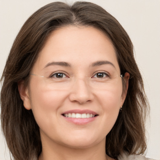 Joyful white young-adult female with medium  brown hair and grey eyes