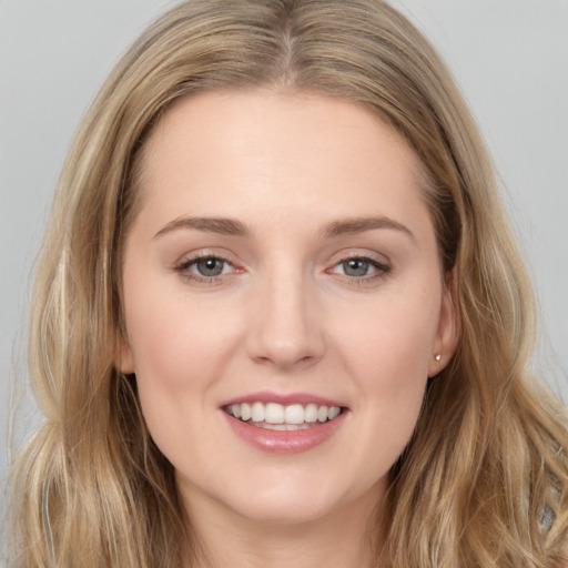 Joyful white young-adult female with long  brown hair and grey eyes