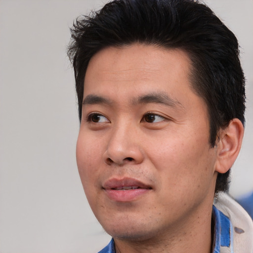 Joyful asian young-adult male with short  black hair and brown eyes