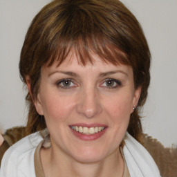 Joyful white young-adult female with medium  brown hair and blue eyes