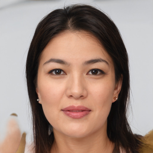 Joyful asian young-adult female with long  brown hair and brown eyes