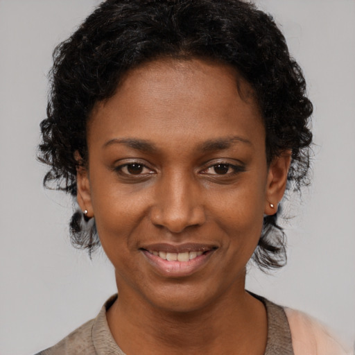 Joyful black young-adult female with short  black hair and brown eyes