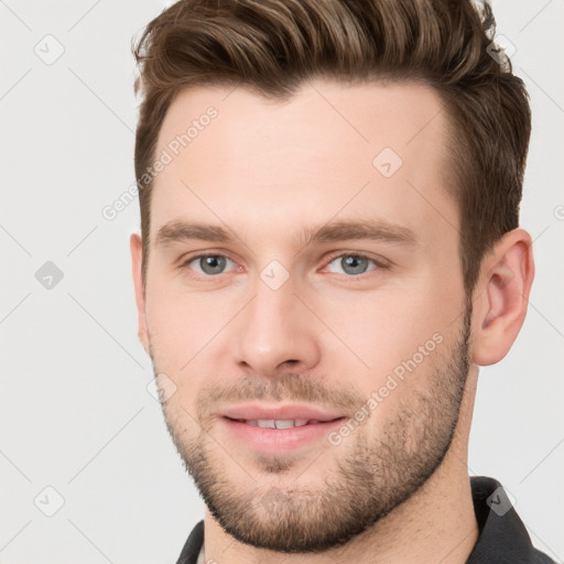 Joyful white young-adult male with short  brown hair and grey eyes